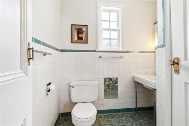 bathroom with tile patterned floors, tile walls, and toilet