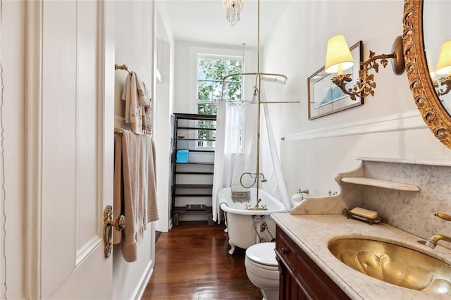 bathroom with a tub to relax in, vanity, hardwood / wood-style flooring, and toilet