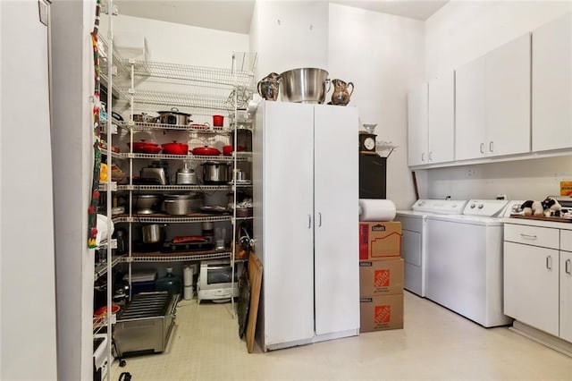 clothes washing area featuring cabinets and independent washer and dryer