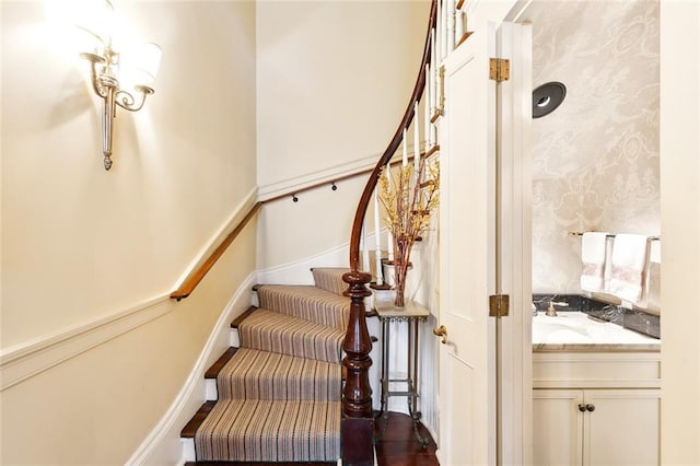 stairs featuring wood-type flooring and sink