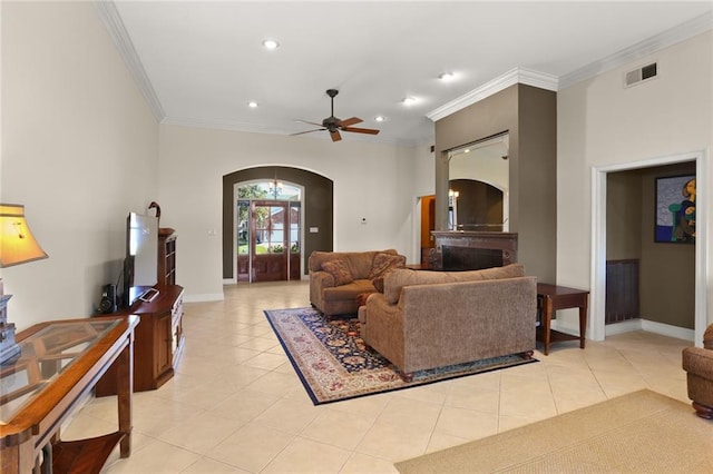 tiled living room with crown molding and ceiling fan