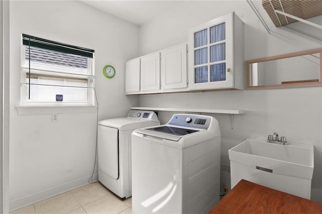 laundry room with light tile patterned flooring, washer and clothes dryer, sink, and cabinets