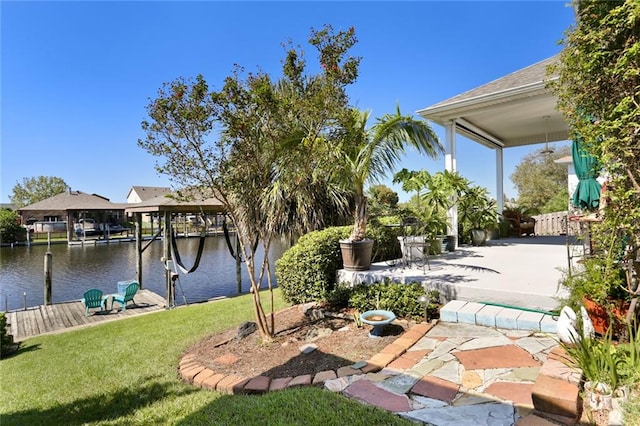 view of yard featuring a water view, a patio, and a dock