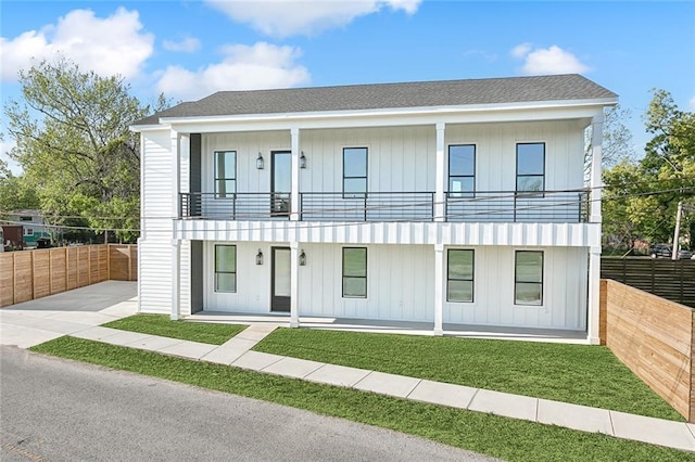 view of front of property with a balcony and a front lawn