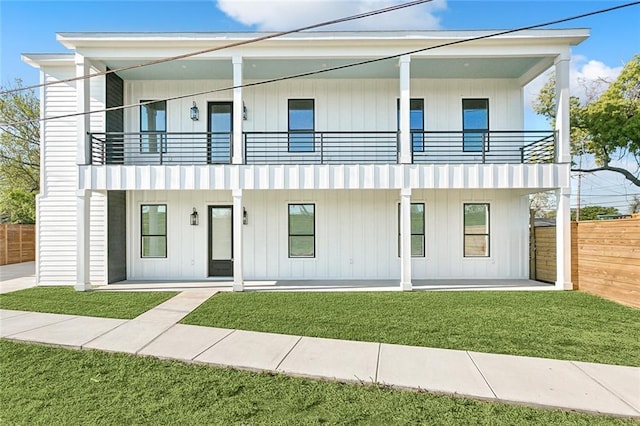 view of front of home with a balcony and a front yard