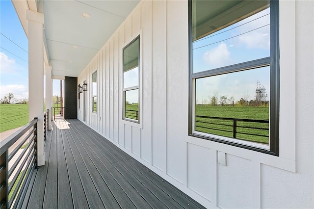 deck featuring covered porch and a lawn