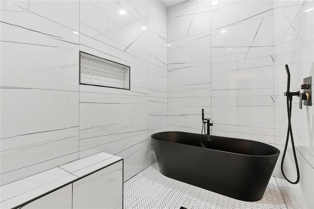 bathroom featuring tile patterned floors and a tub to relax in