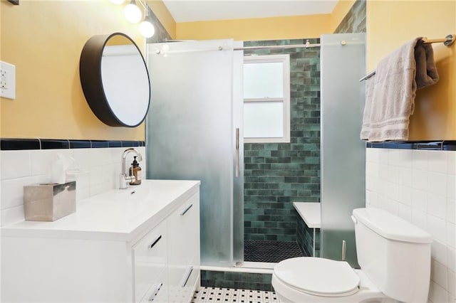 bathroom featuring vanity, tile patterned floors, walk in shower, tile walls, and toilet