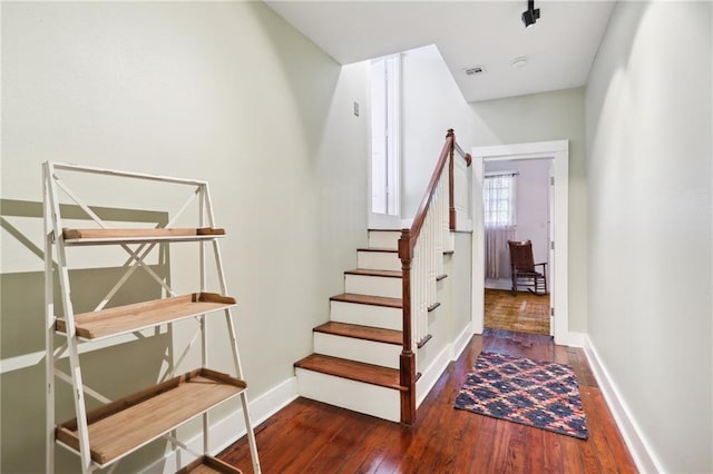 stairway featuring baseboards, visible vents, and wood-type flooring