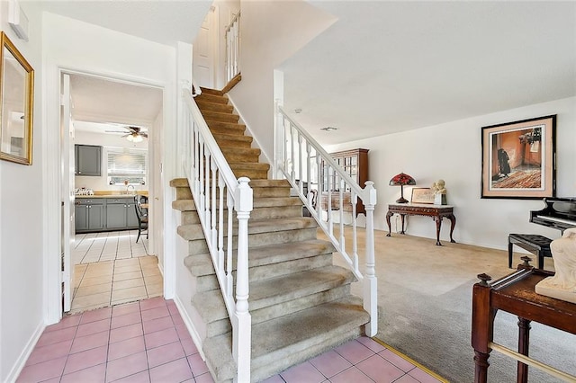 staircase featuring ceiling fan, sink, and tile patterned flooring