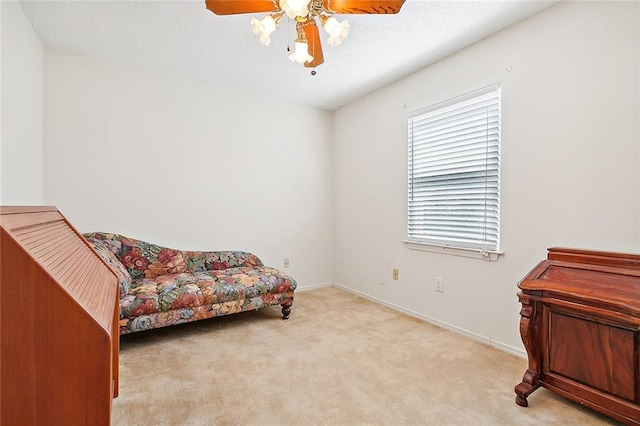 sitting room featuring light colored carpet and ceiling fan