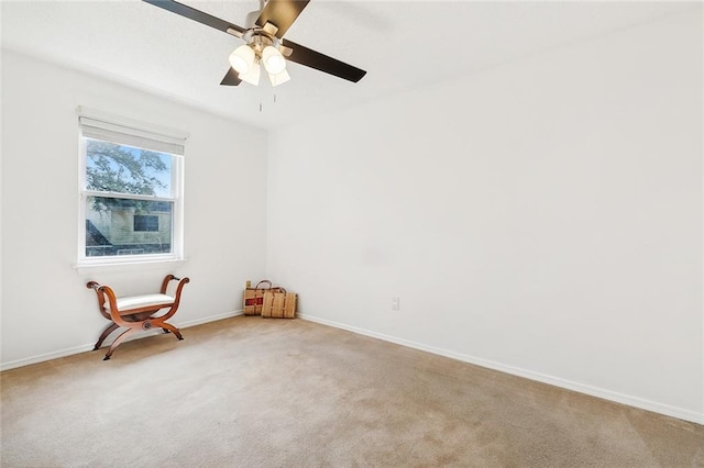 empty room featuring light colored carpet and ceiling fan