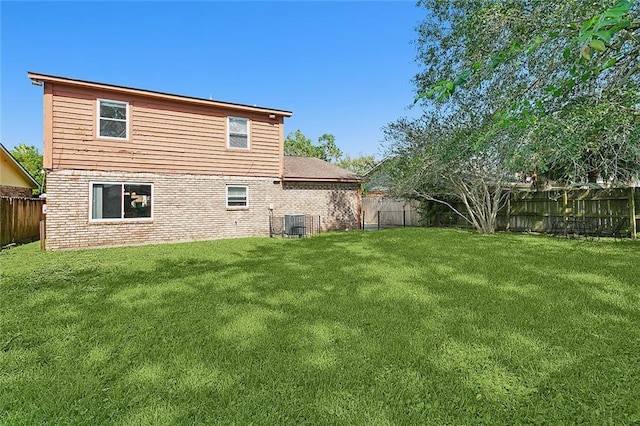 rear view of property featuring central AC unit and a lawn