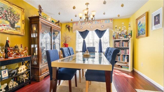 dining space with an inviting chandelier, dark wood-type flooring, and a textured ceiling