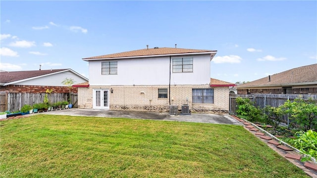 rear view of property with french doors, a yard, and a patio area