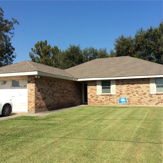 ranch-style house with a garage and a front lawn