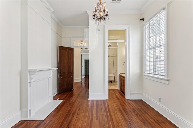 unfurnished bedroom with ensuite bathroom, multiple windows, an inviting chandelier, and dark hardwood / wood-style floors