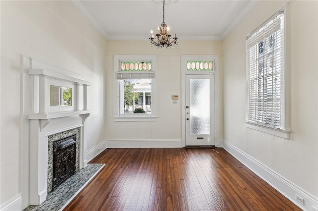 foyer with ornamental molding, a notable chandelier, and dark hardwood / wood-style flooring