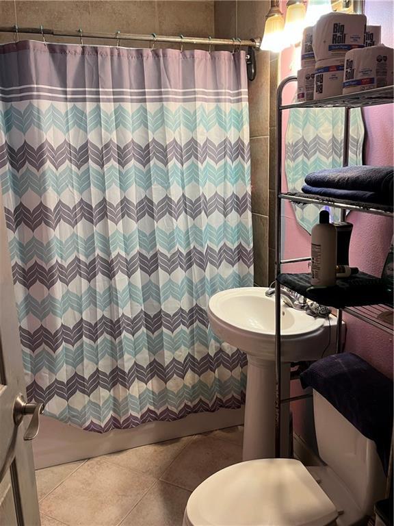 bathroom featuring walk in shower and tile patterned flooring