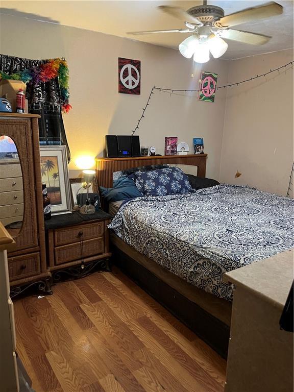 bedroom with ceiling fan and wood-type flooring