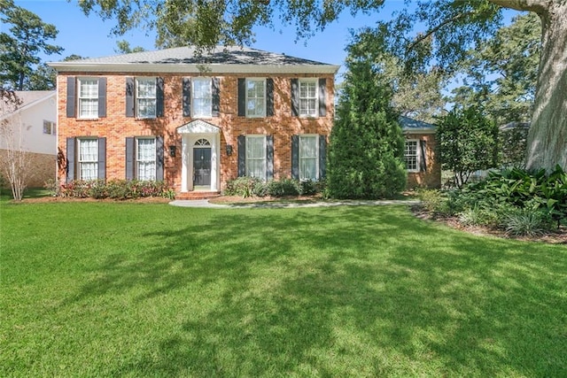 colonial-style house featuring a front lawn