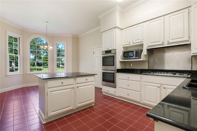 kitchen with decorative light fixtures, appliances with stainless steel finishes, dark tile patterned floors, and white cabinetry