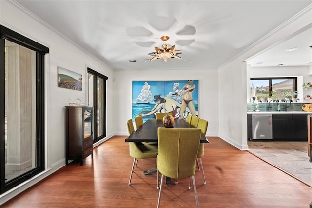 dining space with ornamental molding and hardwood / wood-style floors