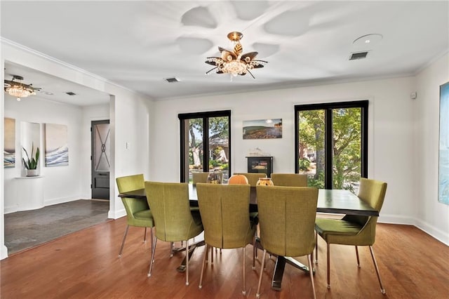 dining area with ornamental molding and hardwood / wood-style flooring