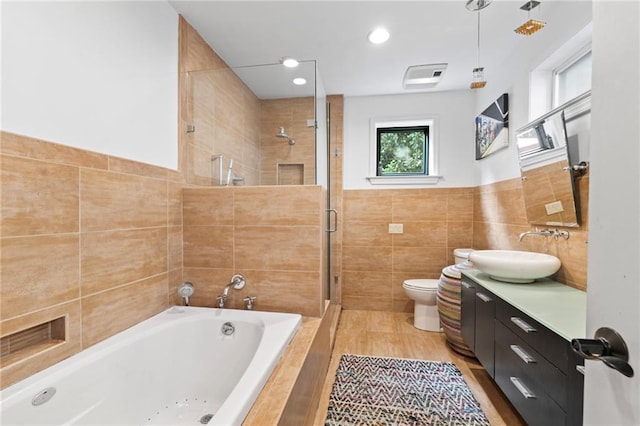 full bathroom featuring vanity, separate shower and tub, tile walls, and toilet