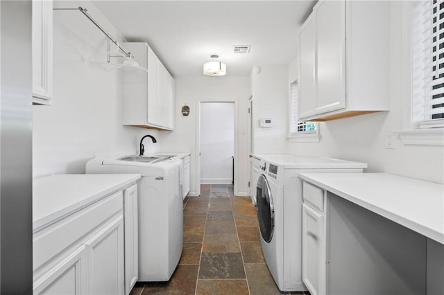 laundry area featuring washing machine and clothes dryer, sink, and cabinets