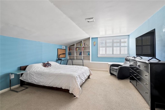 bedroom with light colored carpet and vaulted ceiling