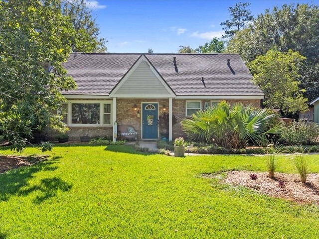 641 Adair St, Mandeville, LA 70448 - view of front of property featuring a front yard, brick siding, and a shingled roof