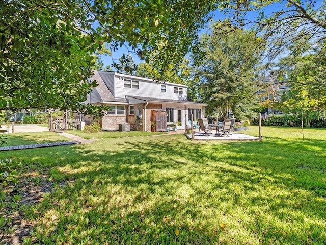 rear view of property with a patio area, cooling unit, and a lawn