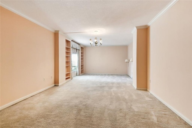 carpeted spare room featuring a textured ceiling, crown molding, and a chandelier