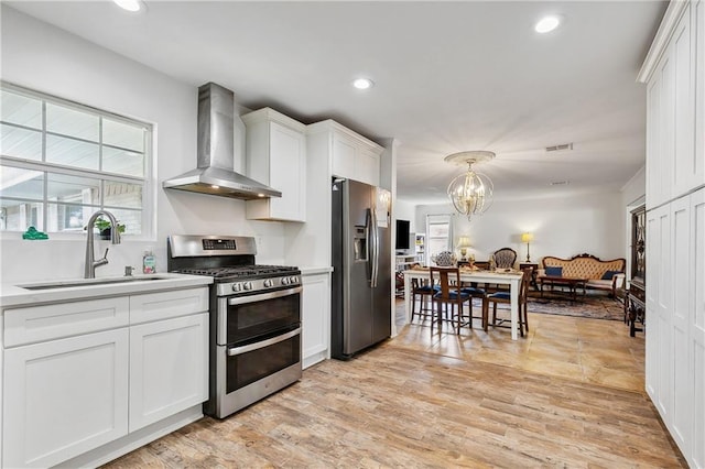 kitchen featuring white cabinets, sink, wall chimney exhaust hood, stainless steel appliances, and light wood-type flooring