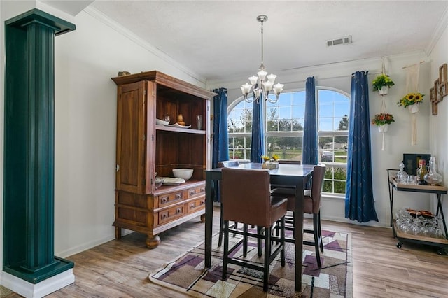 dining space with ornamental molding, a notable chandelier, and hardwood / wood-style floors