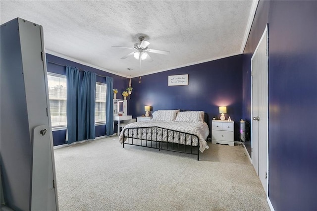 bedroom with ceiling fan, carpet floors, crown molding, and a textured ceiling