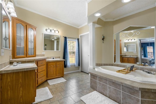 bathroom featuring tile patterned flooring, crown molding, a relaxing tiled tub, and vanity