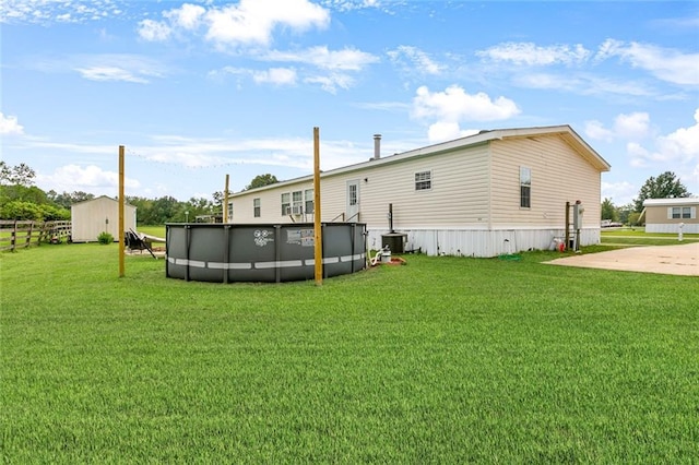 back of property featuring a shed and a lawn