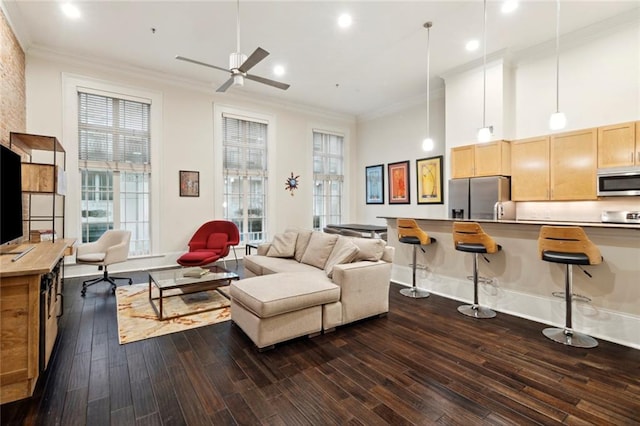 living room with ceiling fan, crown molding, a wealth of natural light, and dark wood-type flooring