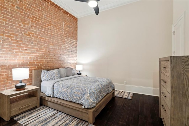 bedroom featuring dark wood-type flooring, crown molding, brick wall, and ceiling fan