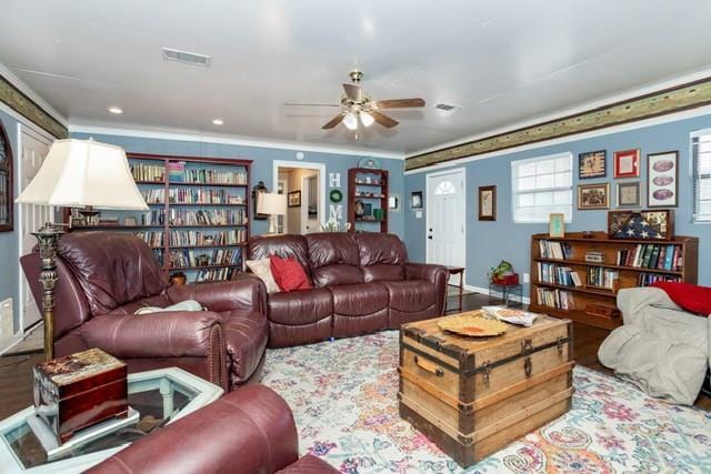 living area with crown molding, visible vents, ceiling fan, light wood-type flooring, and baseboards