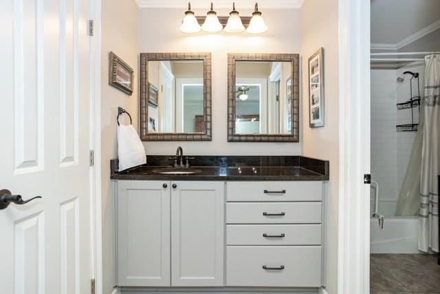 full bath with shower / bath combo with shower curtain, vanity, and crown molding