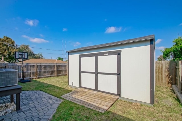 view of outbuilding with central AC and a lawn