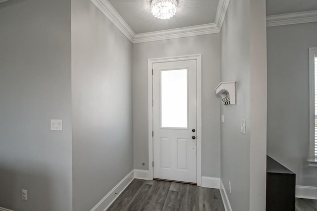 entryway with dark hardwood / wood-style floors, ornamental molding, and a chandelier