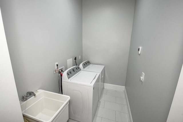 clothes washing area with tile patterned floors, separate washer and dryer, and sink