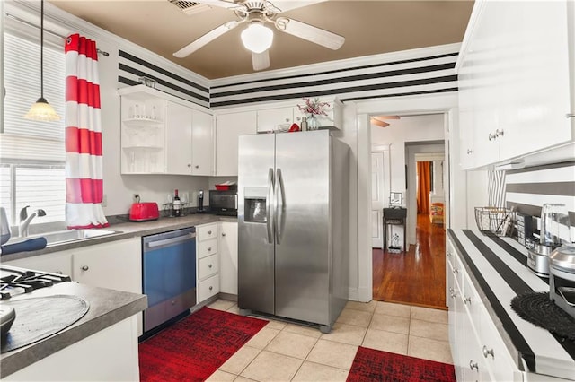 kitchen featuring ornamental molding, white cabinets, decorative light fixtures, light tile patterned floors, and appliances with stainless steel finishes