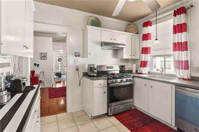 300709 Calhoun St, New Orleans, LA 70118 - kitchen featuring appliances with stainless steel finishes, a sink, under cabinet range hood, dark countertops, and white cabinets