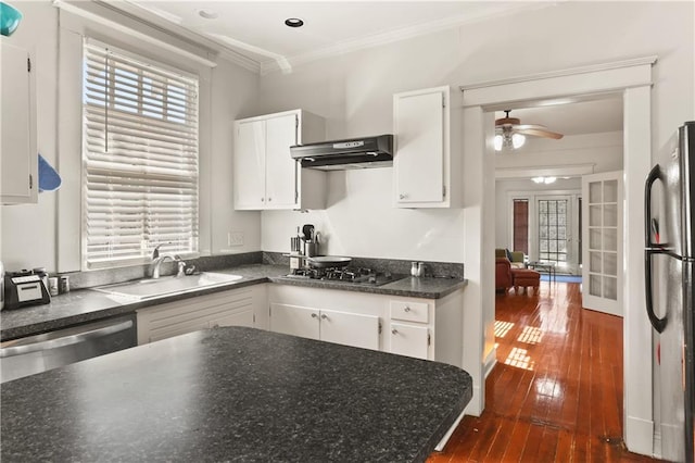 kitchen with white cabinets, exhaust hood, appliances with stainless steel finishes, dark hardwood / wood-style floors, and sink