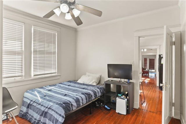 bedroom with ceiling fan, hardwood / wood-style flooring, and crown molding